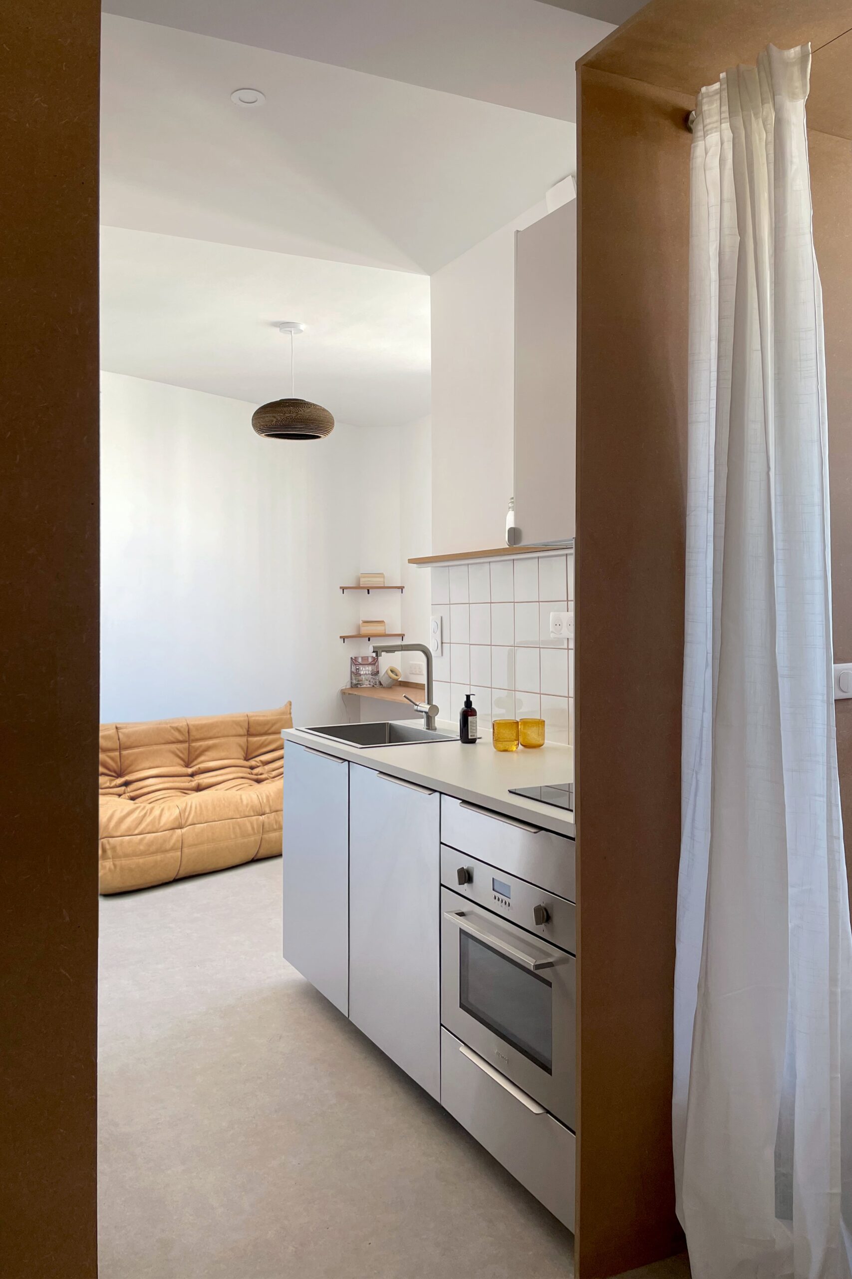 appartement deux pieces design ; cuisine inox ; petite cuisine ouverte ; banquette togo ; salon avec togo