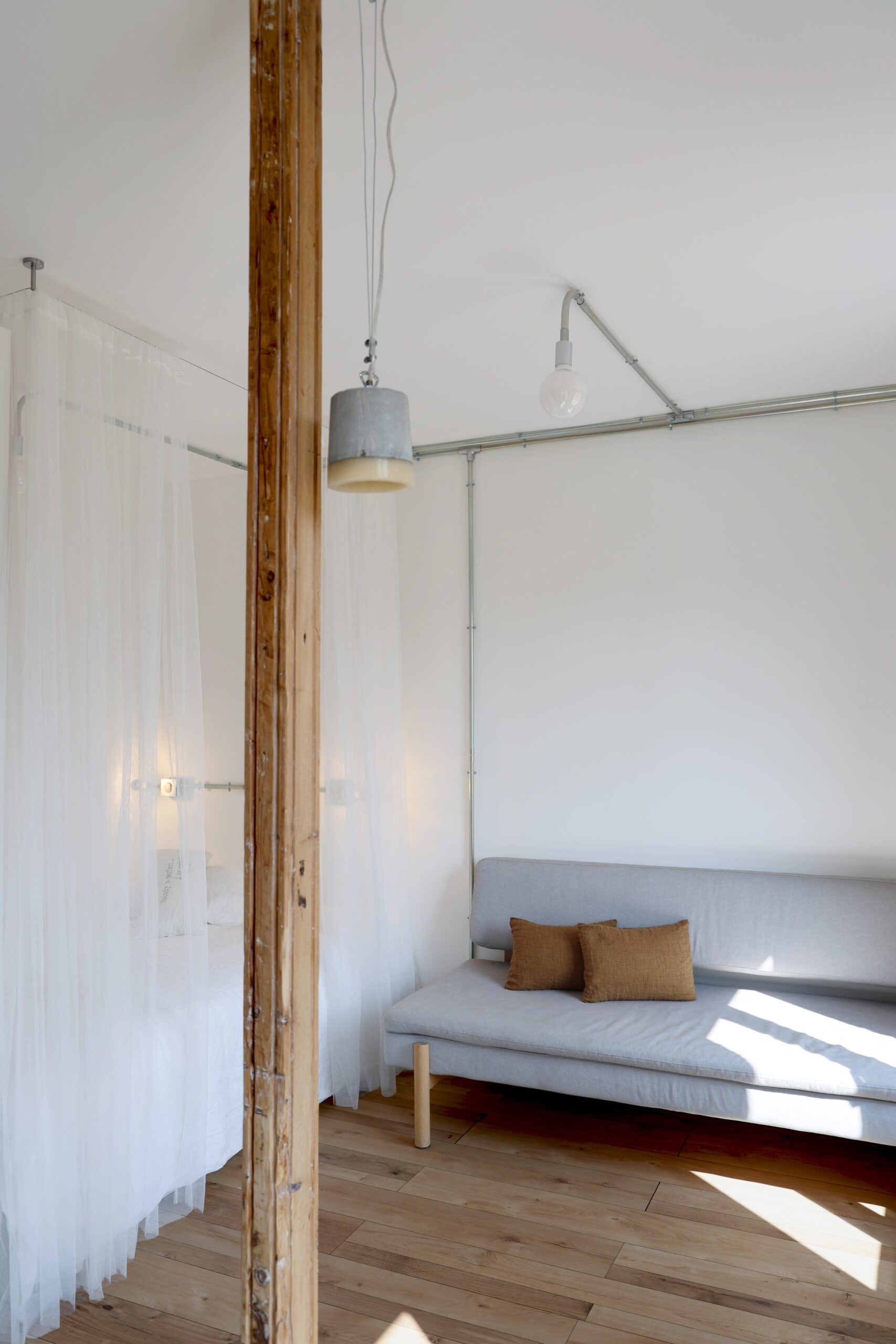appartement_brut_et_minimaliste ; appartement_épuré ; coin_nuit_studio ; gaine_électrique_brute ; salon_et_une chambre_deux_en_un