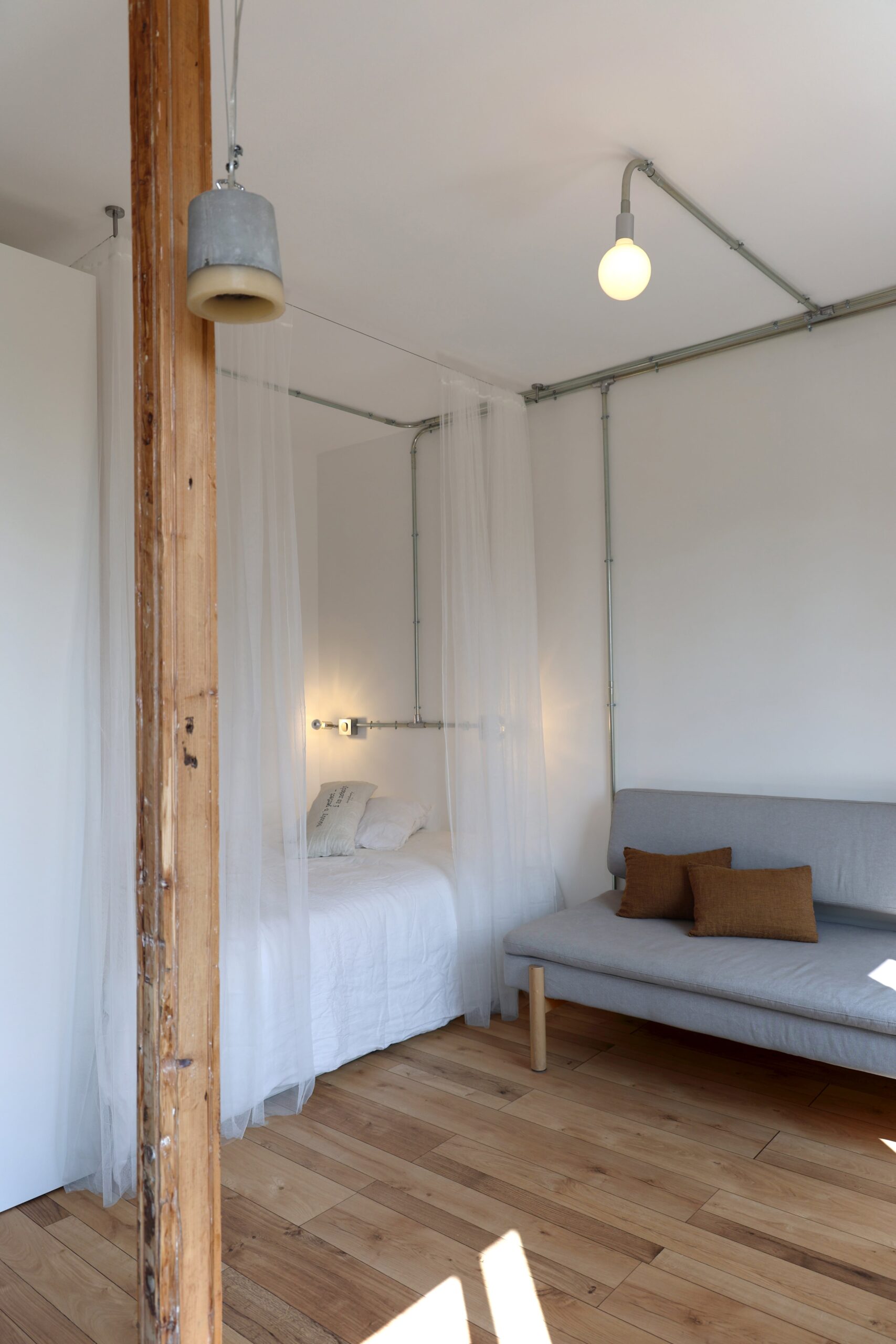 coin_nuit_dans_salon ; studio_optimisé ; coin_salon ; architecture_d_intérieur_minimaliste ; décoration_brute ; gain_de_place